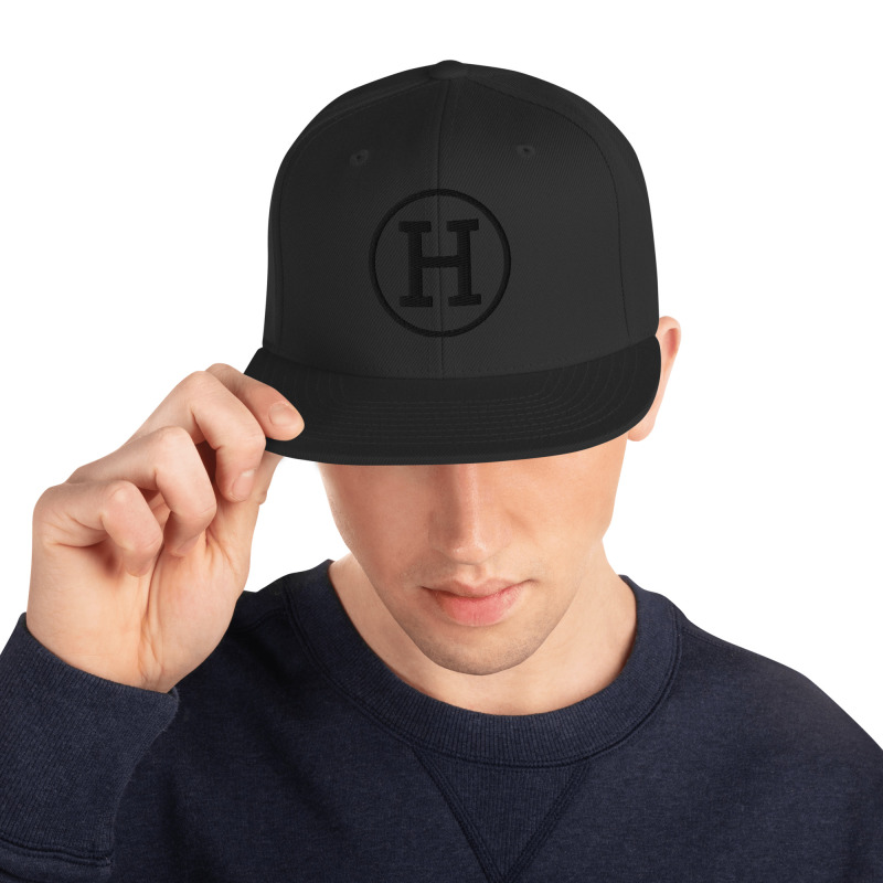 Image of a young man wearing a black snapback hat with the logo for certfied-haters.com embroidered on the front of the hat.