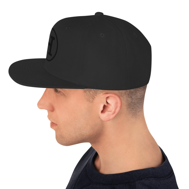 Side view of a man wearing a black snapback hat with the certified-haters.com logo embroidered on the front.