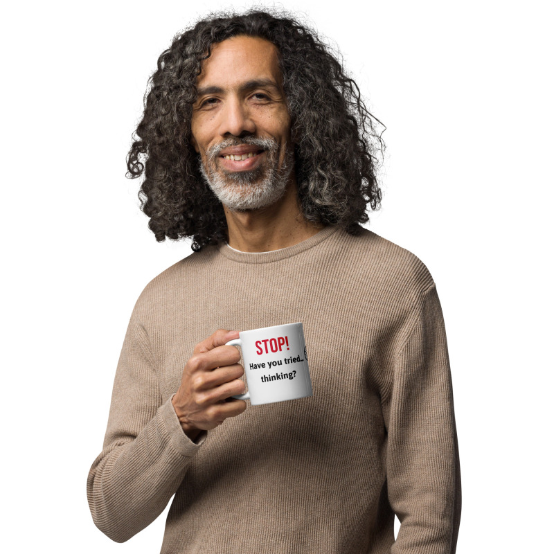 A man holding a funny mug that says "STOP! Have you tried thinking?"